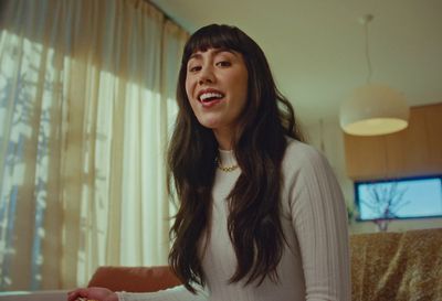 a woman standing in a living room next to a window