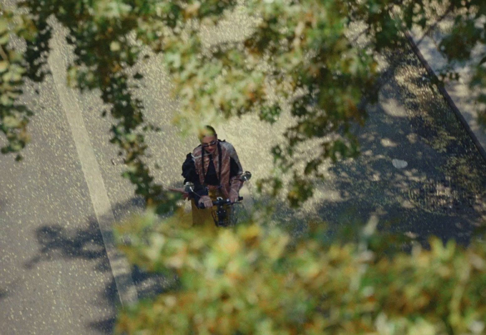 a man riding a skateboard down a street next to trees