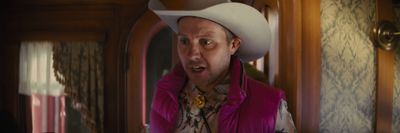 a man in a pink vest and cowboy hat