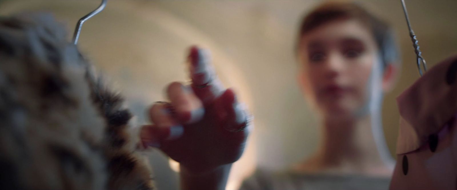 a woman holding her hand up in front of a mirror