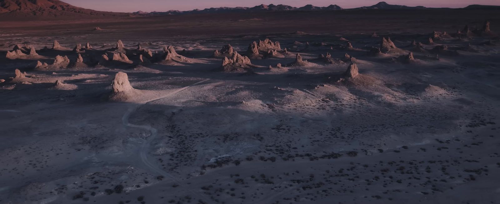 an aerial view of a desert landscape at sunset