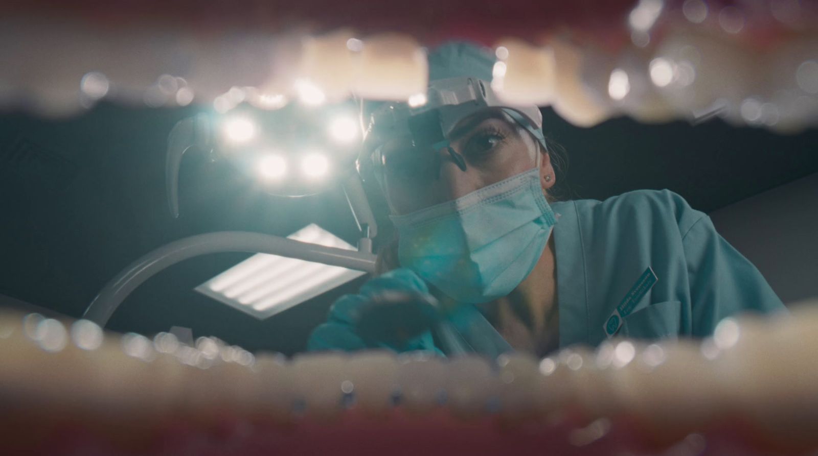 a woman wearing a surgical mask is looking into a mirror