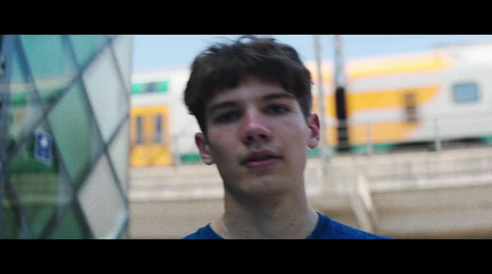 a young man standing in front of a train