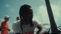 a man with dreadlocks sitting on a bench