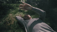 a man laying on the ground in the grass