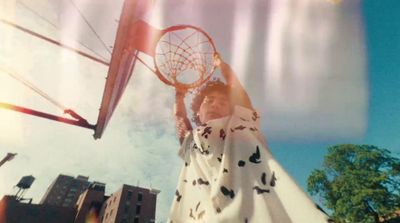 a woman holding a basketball up to the sky