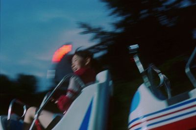 a woman riding a bumper car at night