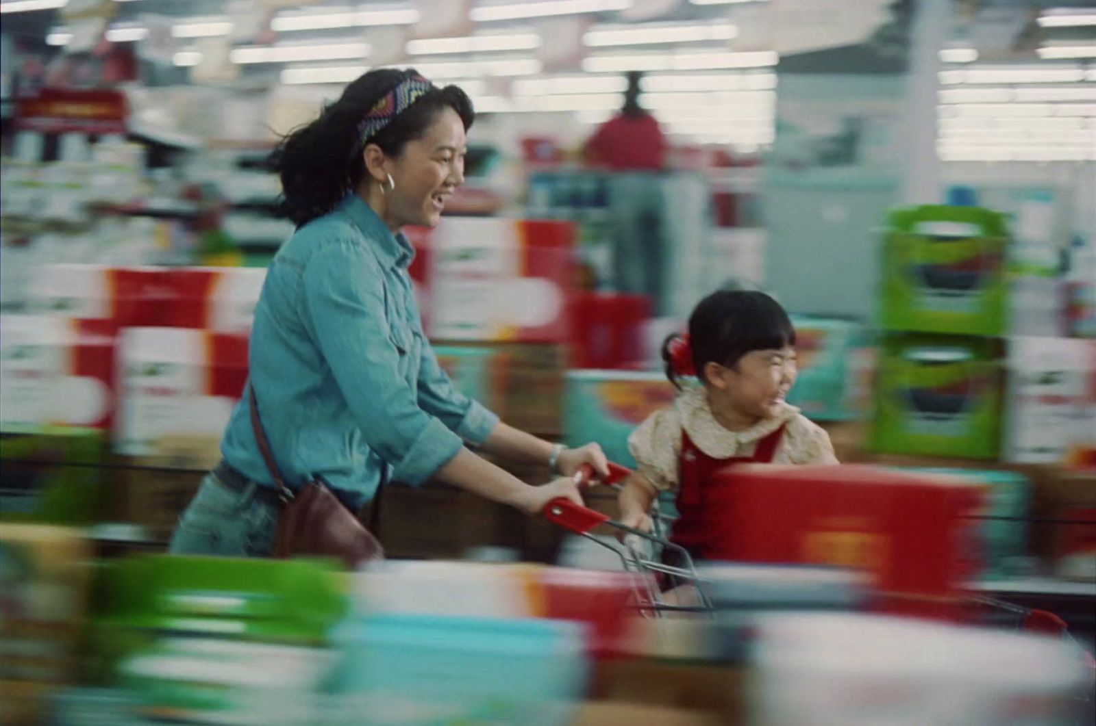 a woman pushing a child in a shopping cart