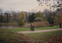 two people walking down a path near a lake