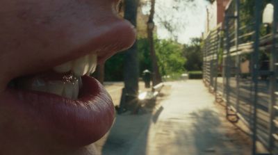 a person with their mouth open and a building in the background