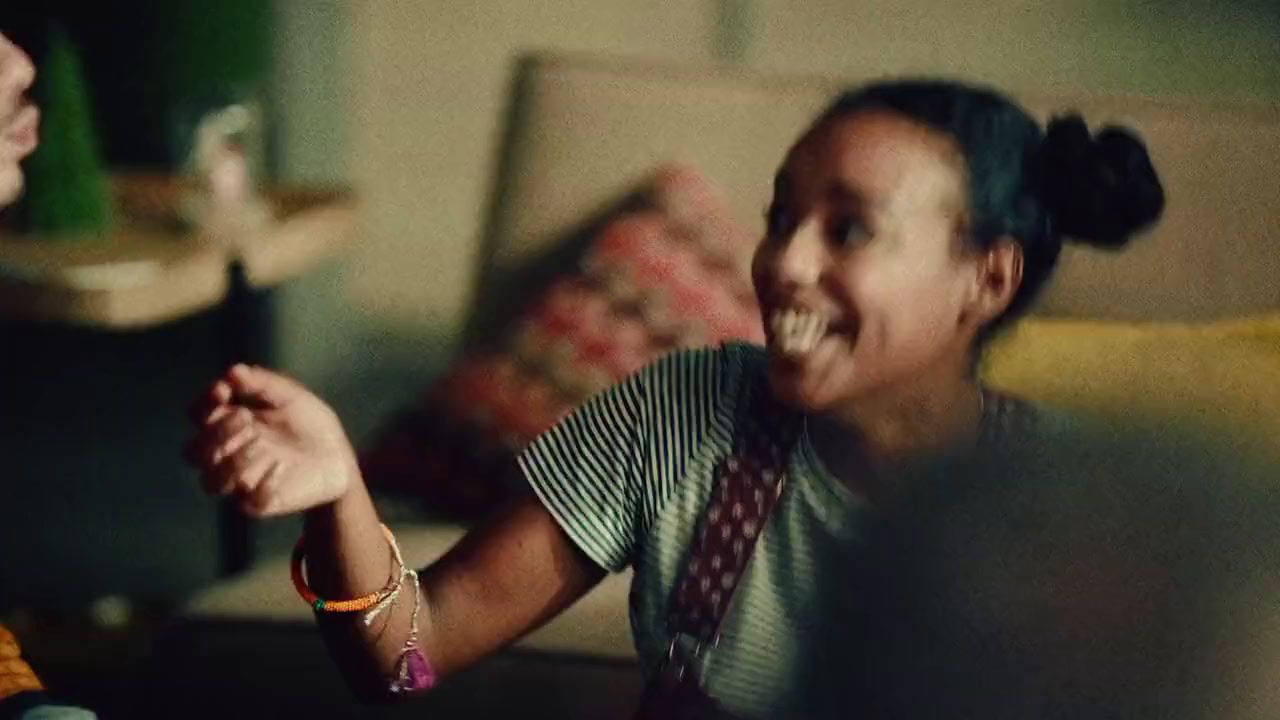 two young women sitting on a couch laughing