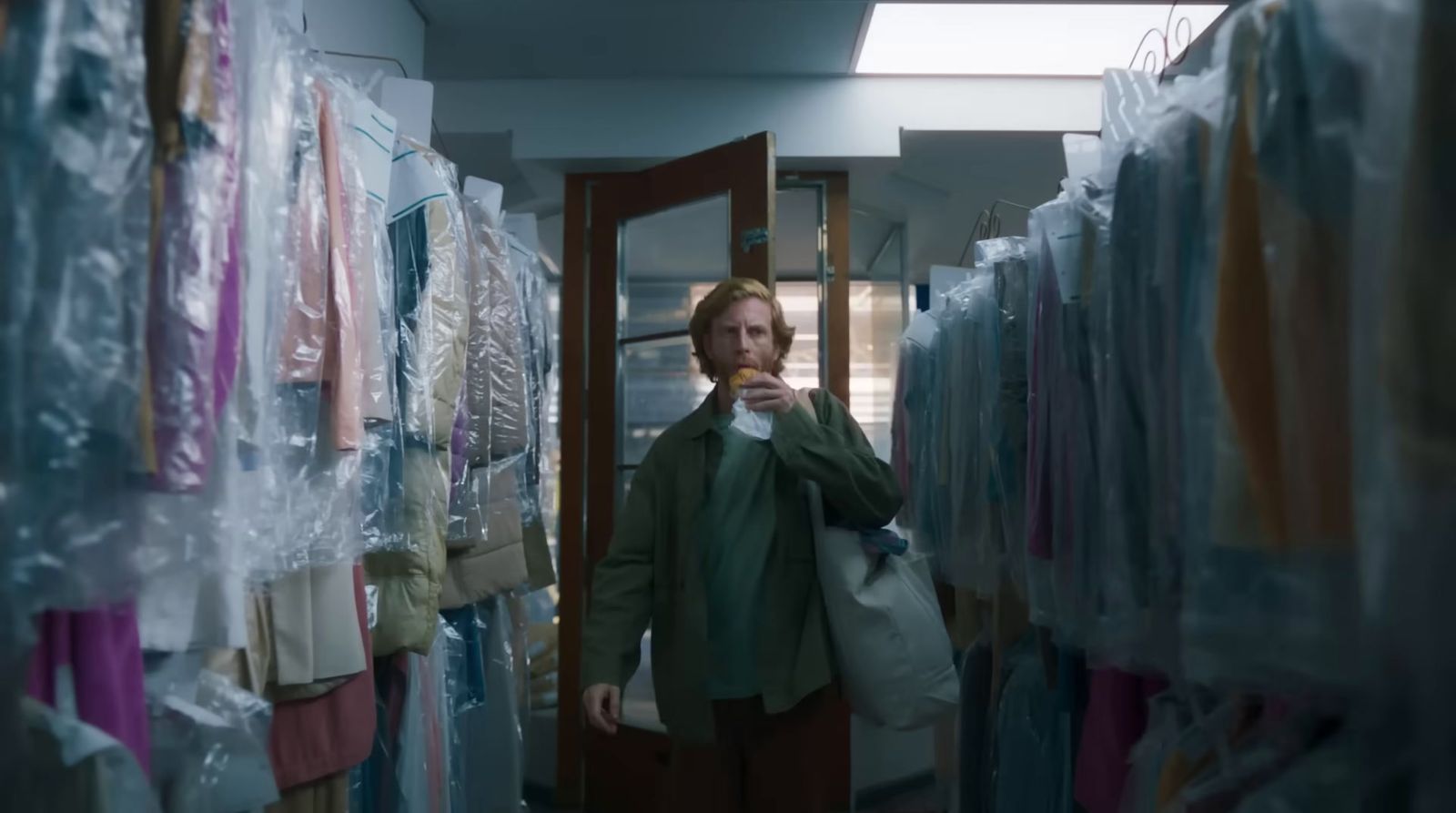 a man standing in a room with lots of clothes