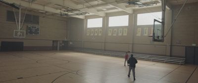 a person standing on a basketball court in a gym