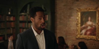 a man sticking his tongue out in front of a painting