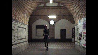 a woman walking down a hallway in a building