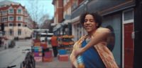 a woman standing in front of a store on a city street