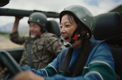 a woman driving a vehicle with a helmet on