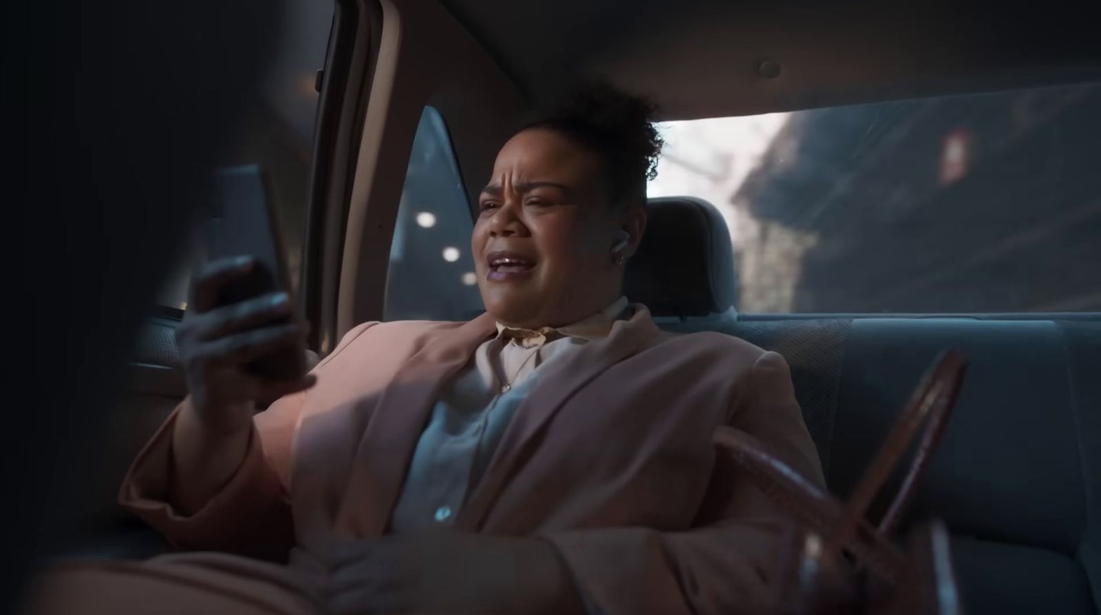 a woman sitting in a car holding a cell phone