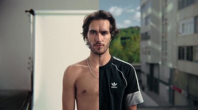 a man with no shirt standing in front of a building