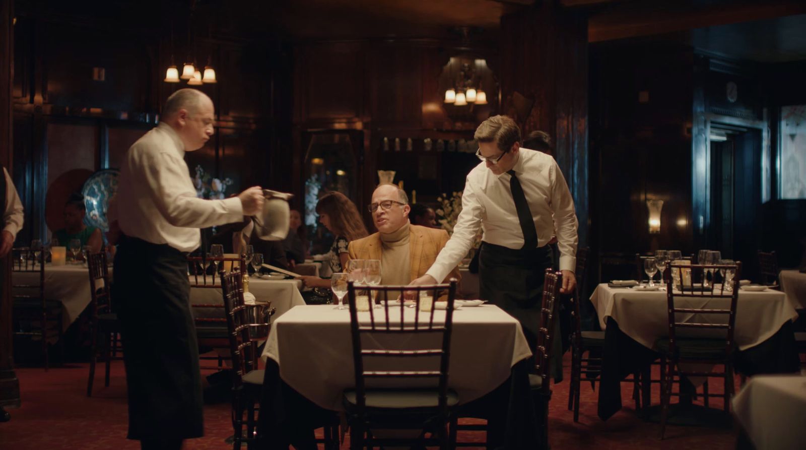 a group of men standing around a dining room table