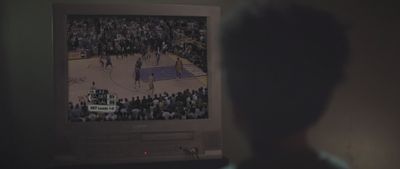 a person watching a basketball game on a tv