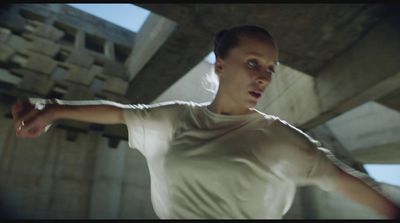 a woman in a white t - shirt is holding her arm out