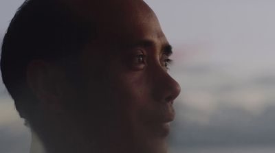 a close up of a man's face with clouds in the background