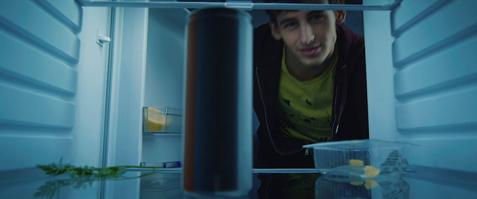 a man is looking in the refrigerator at something