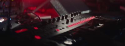 a close up of a mixing desk with a red light