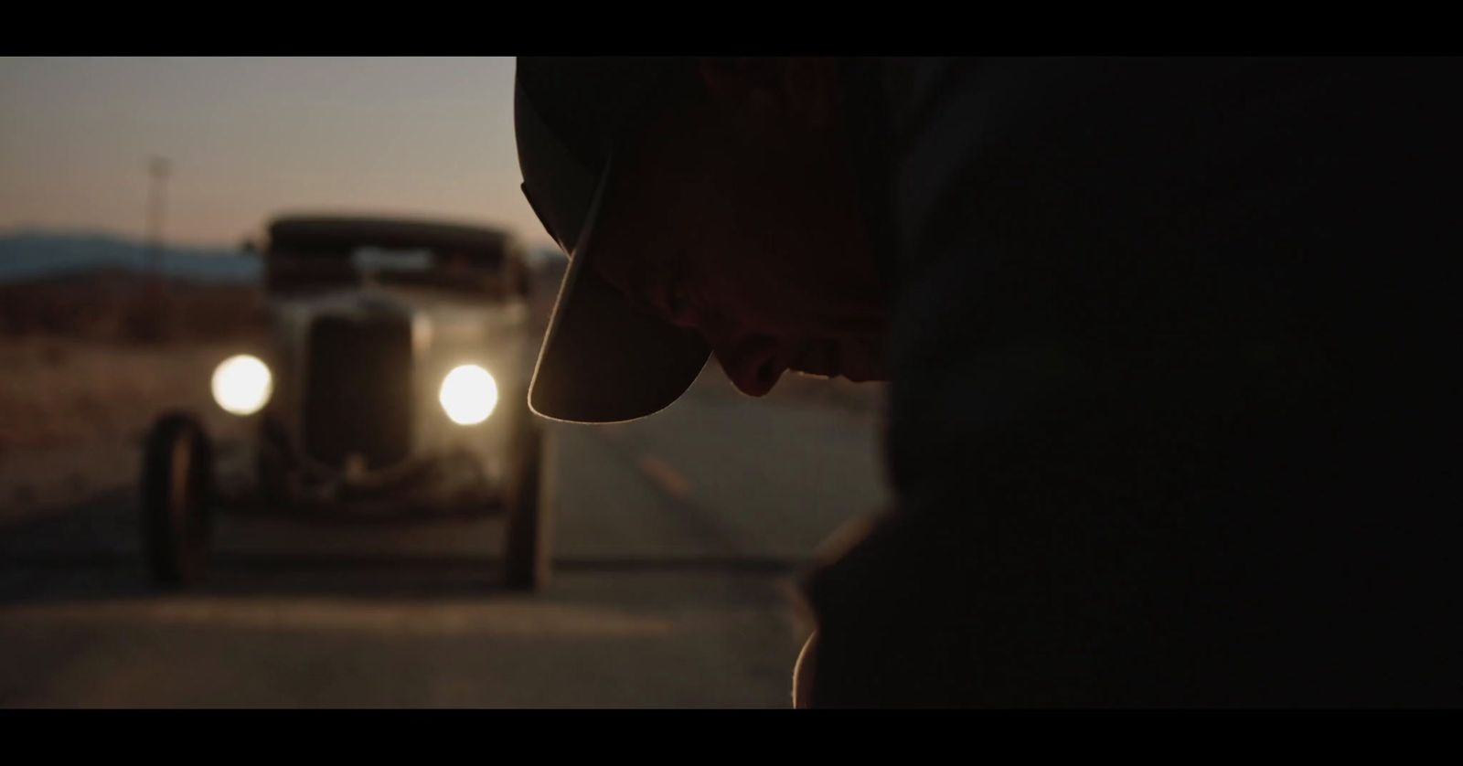 a man standing next to a truck on a road