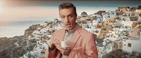 a man in a pink suit holding a cup of coffee