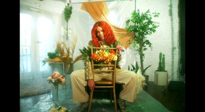 a woman with red hair sitting on a chair