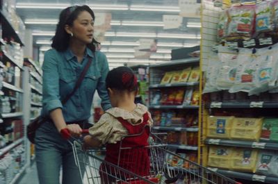 a woman pushing a child in a shopping cart