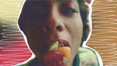 a woman eating a piece of fruit in front of her face