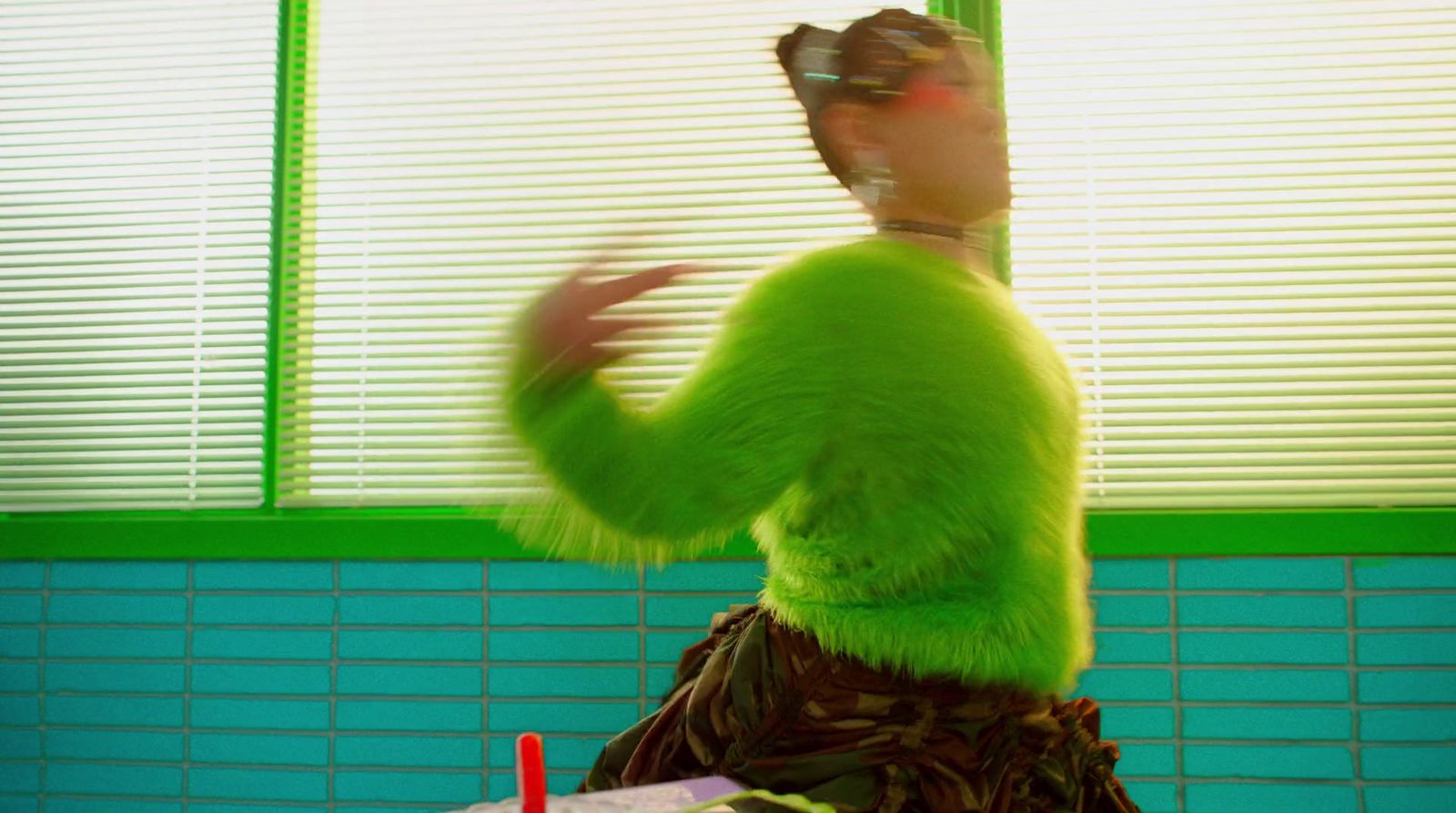 a woman in a green outfit is dancing