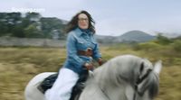 a woman riding on the back of a white horse