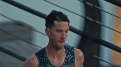 a man in a tank top running down a street