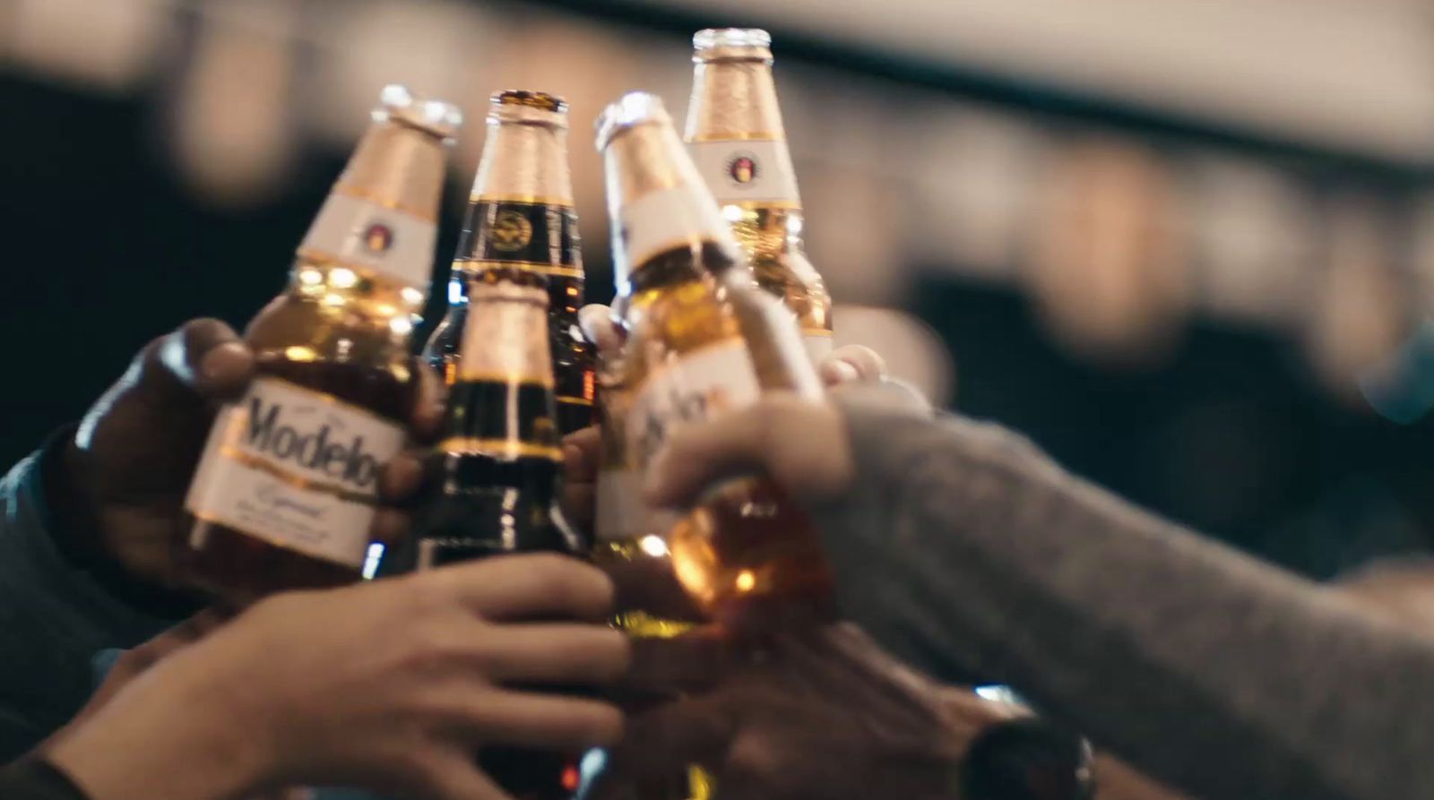 a group of people holding up bottles of beer