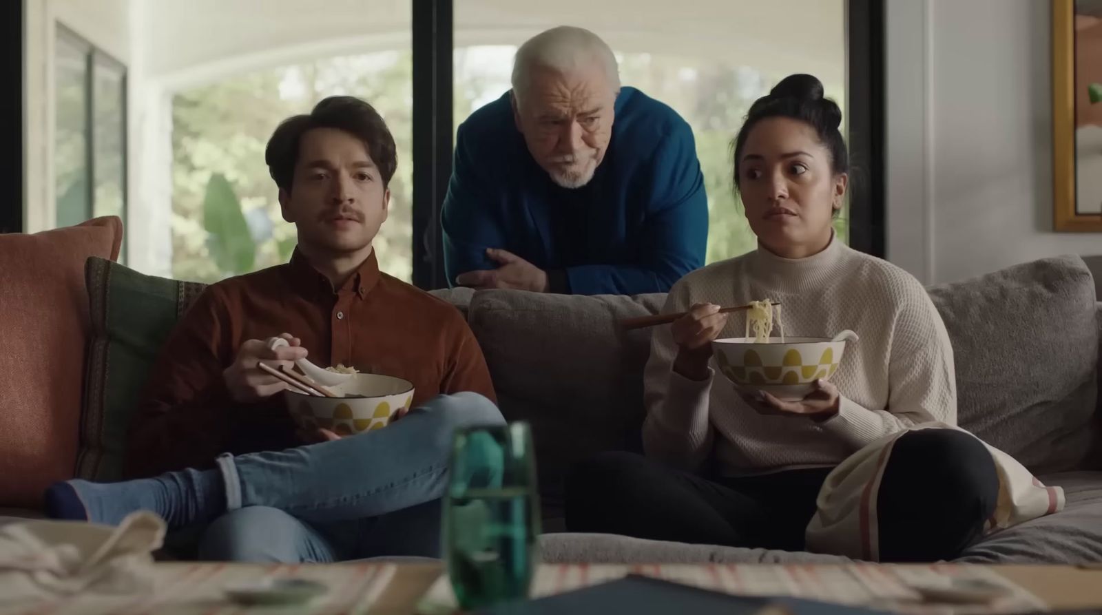 a group of people sitting on a couch eating food