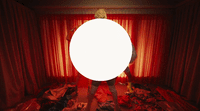 a person standing in a room with a large round object