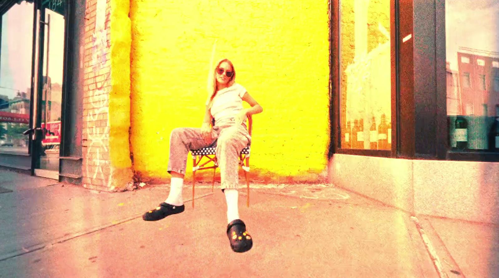 a woman sitting on a chair in front of a yellow wall