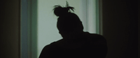 a person standing in front of a window in a dark room