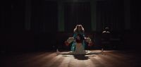 a woman sitting on the floor in a dark room