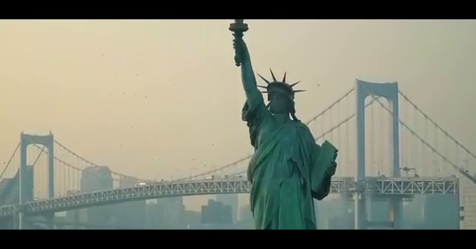 the statue of liberty stands in front of a bridge