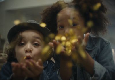 two young girls are looking through a mirror