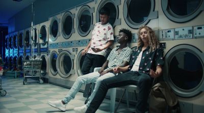 a group of people sitting in front of a row of washers