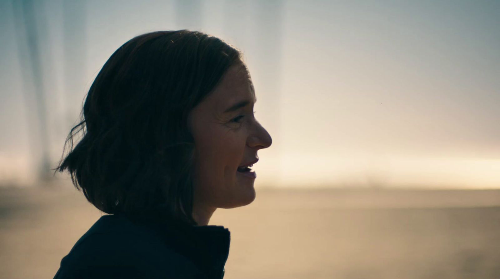 a woman standing in front of a body of water