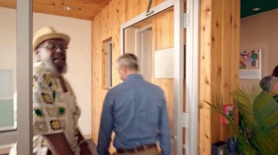 a man in a hat is walking into a room