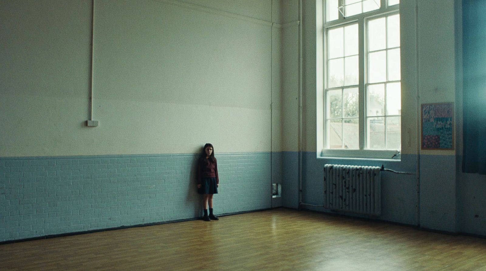 a woman standing in a room next to a window