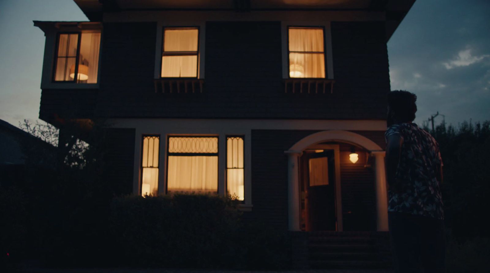 a man standing in front of a house at night